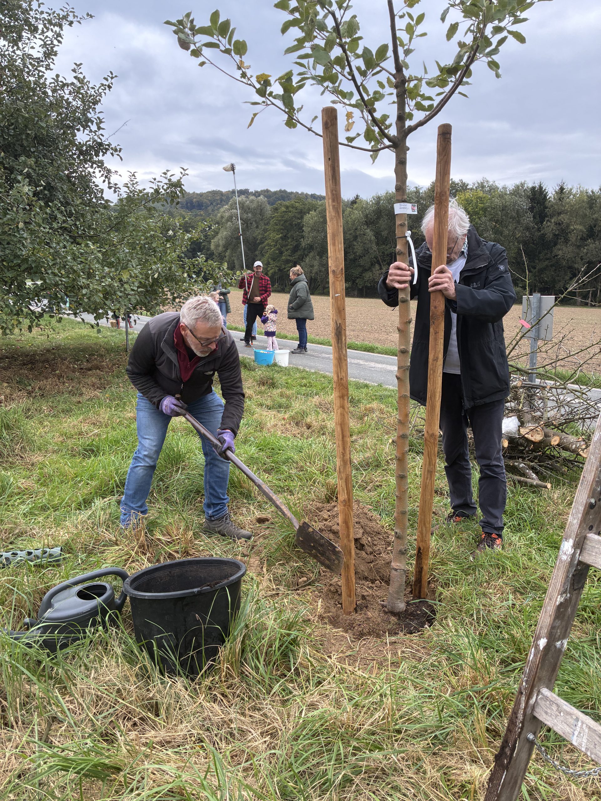 Reiner Kirberg und Bernd Groeger pflanzen einen Apfelbaum